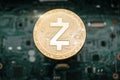 Gold zcash coin, on background of computer motherboard