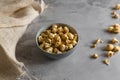 Golden airy popcorn in a gray plate on a concrete table on a piece of light burlap, fried crispy corn for watching a movie or