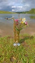 Golden alto saxophone on a background of nature. Original saxophone with a bouquet of summer summer flowers. Art. Cover for jazz.