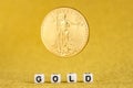 Golden american eagle one ounce coin levitating on the letters gold made of white dices