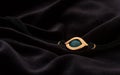 Golden amulet eye pendant bracelet on velvet dark fabric Royalty Free Stock Photo