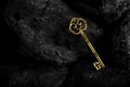 Golden Antique Key on Black Stone Background Royalty Free Stock Photo
