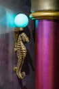 Golden antique seahorse marine life animal sculpture lamp with a blue light bulb Royalty Free Stock Photo