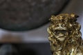 Gold Asian Lion Statue With Gong in Background Shallow DOF