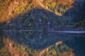 Golden autumn in the mountains reflected in Issyk lake surrounded by yellow forest in Almaty, Kazakhstan Royalty Free Stock Photo