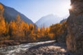 Golden autumn in the mountains with sun rays with a river and a yellow forest with banks. Issyk Gorge in Almaty mountains in Royalty Free Stock Photo