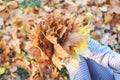 Golden autumn time. Yellow maple leaf on the young woman knee. Fall colors in old city park