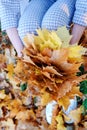 Golden autumn time. Yellow maple leaf on the young woman knee. Vertical photo