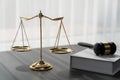 Golden balanced scale and gavel on desk with book in law office. equility