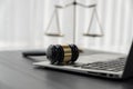 Golden balanced scale and gavel on desk with laptop in law office. equility