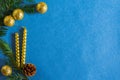 Golden balloons, candles, fir branches on a blue background Royalty Free Stock Photo