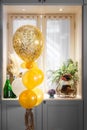 Golden balloons. Glittery and golden balloons for celebration or special occasion by the window Royalty Free Stock Photo