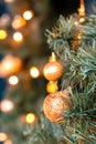 Golden balls and bokeh lights on a green Christmas tree, winter background for greeting card, atmosphere of cosiness and Royalty Free Stock Photo