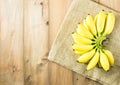 Golden banana on gunny sack cloth and wooden table