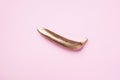 Golden banana on pink background. Creative food concept. Top view. Flat lay. Single exotic gold fruit
