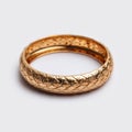 Golden bangle with textured surface resting on a stark white background Royalty Free Stock Photo
