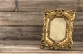 Golden baroque picture frame on wooden background Royalty Free Stock Photo