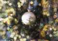 Golden bauble, Christmas ornament with blurred magic garland lights