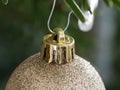 Golden Bauble hanging Down From a Branch of Christmas Tree. Shallow Depth Field