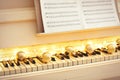 Golden baubles and fairy lights on piano keys, closeup. Christmas music Royalty Free Stock Photo