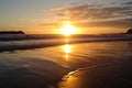 golden beach sunset, with the sun setting over the ocean, reflecting in the water Royalty Free Stock Photo