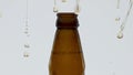 Golden beer splashing bottle after opening in super slow motion close up.