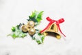 Golden bell with red ribbon and green leaf with balls on white snow Royalty Free Stock Photo