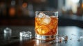 Golden beverage in a glass with ice, on a table in a dimly lit setting Royalty Free Stock Photo
