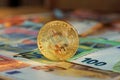 Golden bitcoin BTC on euro banknotes Royalty Free Stock Photo