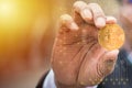 Golden bitcoin in businessman hand, YoungÃ¢â¬â¢s fingers catch bitcoin in the air, bokeh, morning light background, content to