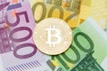 Golden Bitcoin close-up. Euro currency as a background. Macro ph Royalty Free Stock Photo