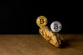 Gold and silver Bitcoin Coins balances on natural stones on dark background. Blockchain cryptocurrency, store of value