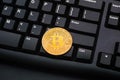 Golden bitcoin coin on a black computer keyboard Royalty Free Stock Photo