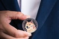 Golden bitcoin coin Dogecoin DOGE group included with Cryptocurrency on hand business man wearing a blue suit. Filed and put and Royalty Free Stock Photo
