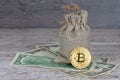 Golden bitcoin coin over dollar banknotes