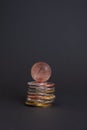 Golden bitcoin coin with bitcoin symbol on a stack of different bitcoins coins over dark background. Royalty Free Stock Photo