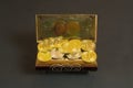 Golden bitcoin coins and banknote in the treasure trove, cryptocurrency in wooden chest, gift, decoration on black paper
