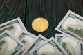 Golden bitcoin among dollar bills