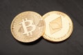 Golden Bitcoin and Ethereum on black wooden table