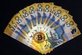 Golden Bitcoin glowing on top of Australian 50 dollar banknotes on black background. Royalty Free Stock Photo