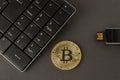 Golden bitcoin, keyboard and flash drive on a dark background top view