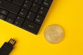 Golden bitcoin, keyboard and flash drive on a yellow background