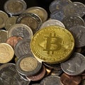 Golden bitcoin over a pile of coins. Royalty Free Stock Photo