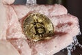 Golden bitcoin in the palm of a hand. Money laundering