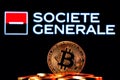 Golden bitcoin in a pile of coins on the background of Societe Generale bank logo Royalty Free Stock Photo