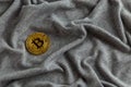 Golden bitcoin shiner on gray crumpled cotton cloth