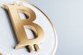 Golden bitcoin sign on light backdrop. Crypto and finance concept.