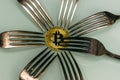 Golden bitcoin and silver forks around Royalty Free Stock Photo