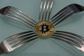 Golden bitcoin and silver forks around Royalty Free Stock Photo