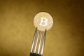 Golden bitcoin in siver fork on abstract background Royalty Free Stock Photo